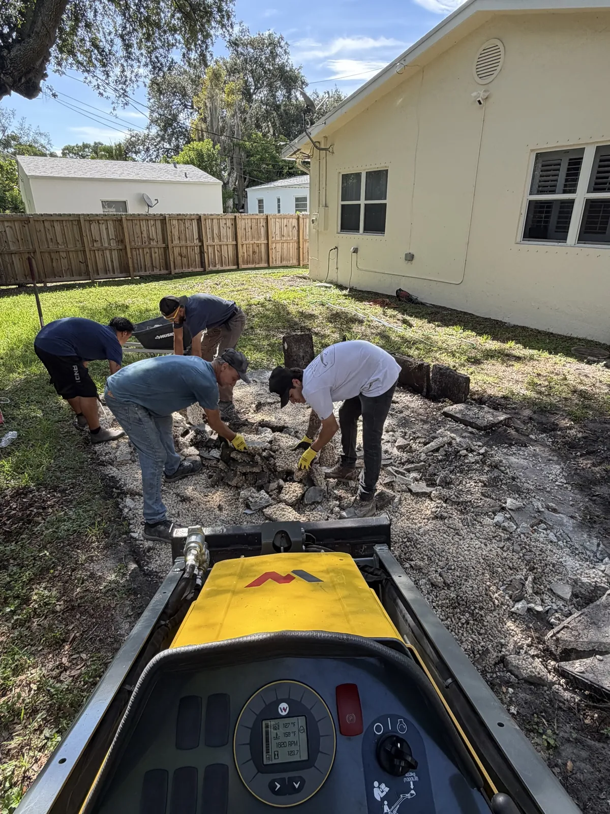 Crew clearing backyard debris during residential demolition in Broward County FL