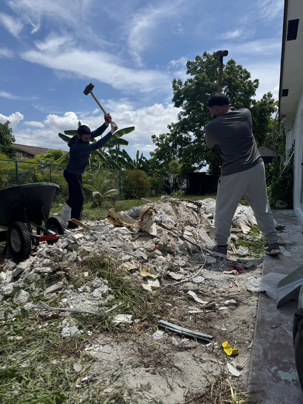 Crew loading broken concrete debris into a skid steer loader in Broward County FL